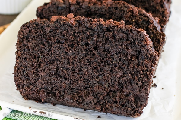 A white tray with slices of chocolate zucchini bread on it.