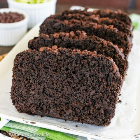 Slices of chocolate zucchini bread on a white plate.