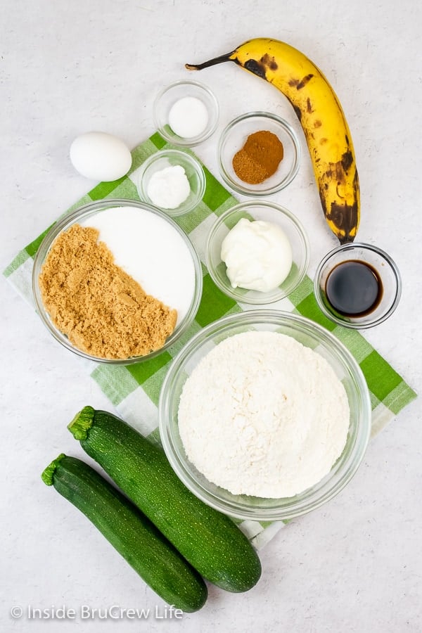 A white board with the ingredients needed to make a zucchini banana cake on it.