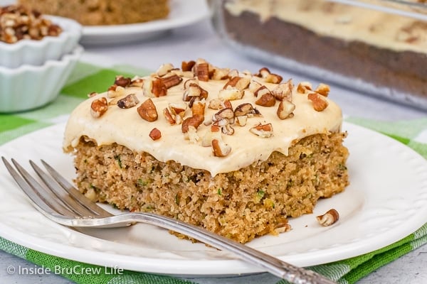 A square of zucchini cake topped with caramel frosting and pecans.