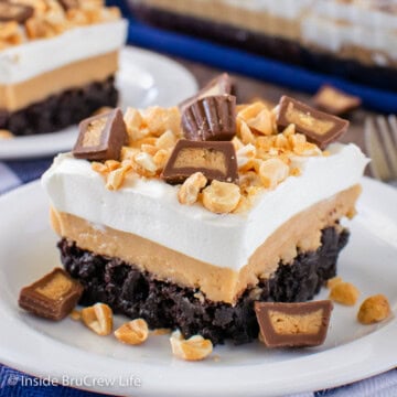 A layered brownie dessert with peanut butter on a white plate.