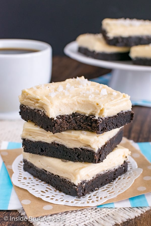 Three chocolate sugar cookie bars frosted with salted caramel frosting stacked on top of each other