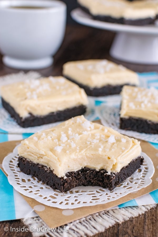 A white doily with a salted caramel chocolate cookie bar on it with a bite missing