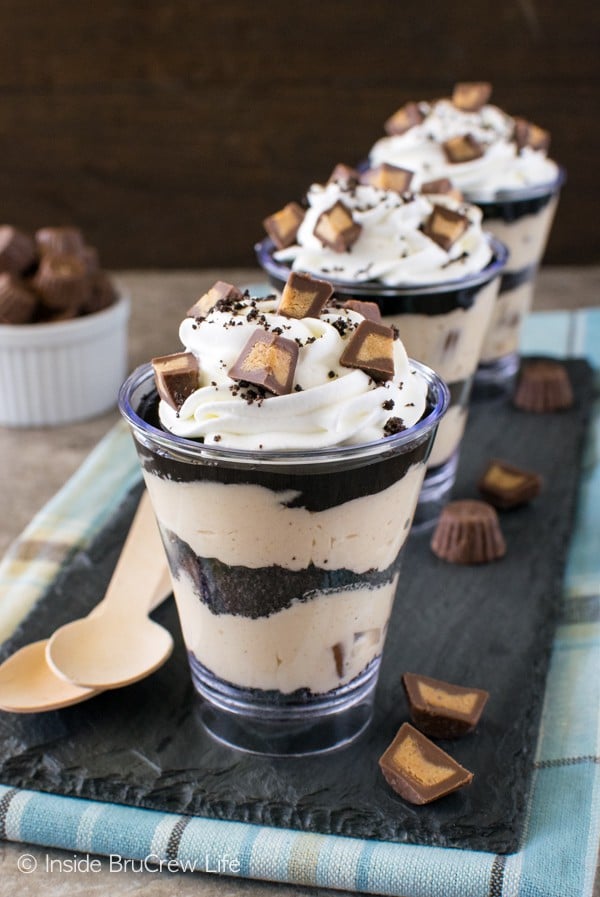 Layers of creamy peanut butter and cookie crumbs in these No Bake Peanut Butter Fudge Cheesecake Parfaits are the little treats you need for your next party. Great mini dessert recipe!
