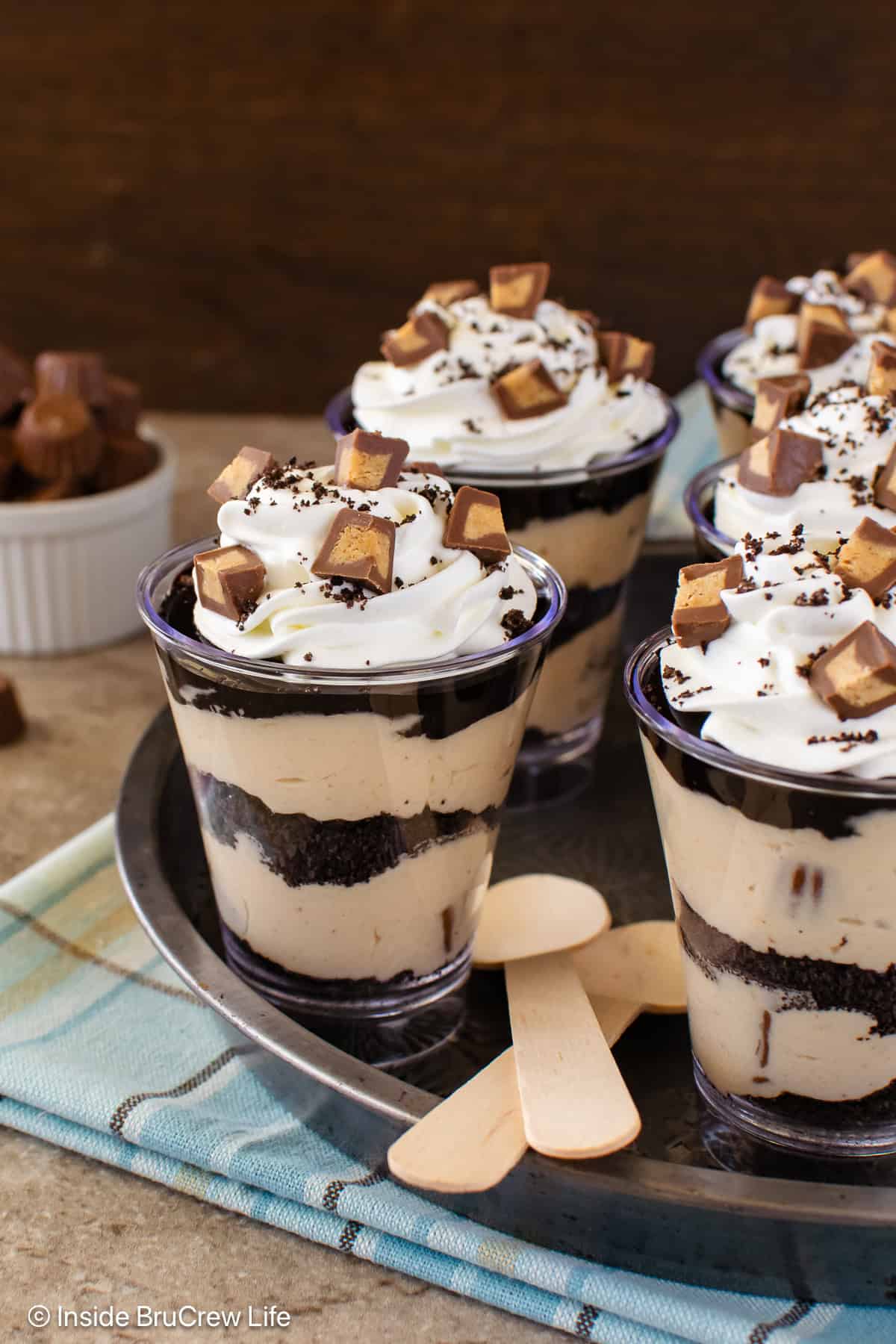 A tray of peanut butter fudge parfaits on a towel and board.
