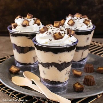 Three peanut butter chocolate mousse parfaits on a silver tray.