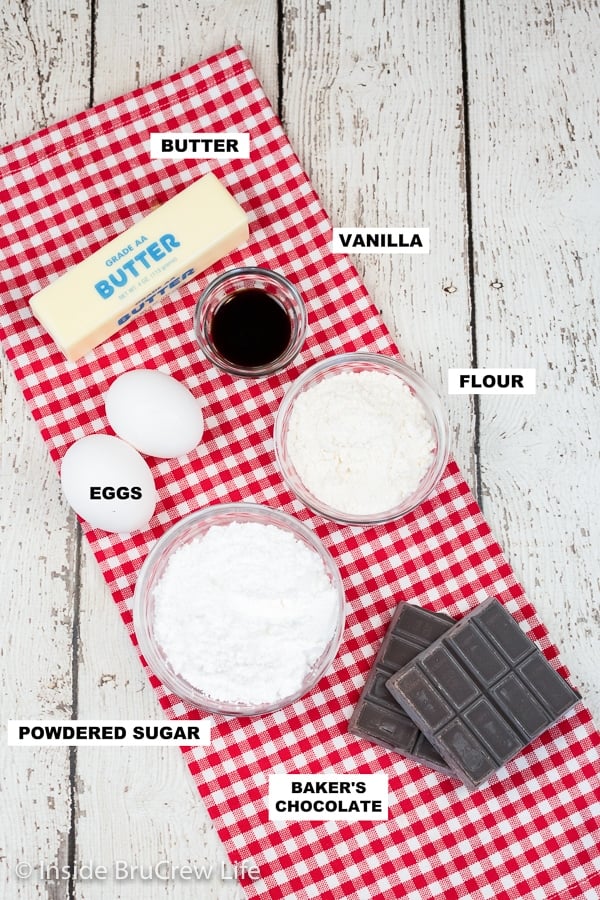 A red and white towel on a white board with bowls of ingredients needed to make lava cakes.