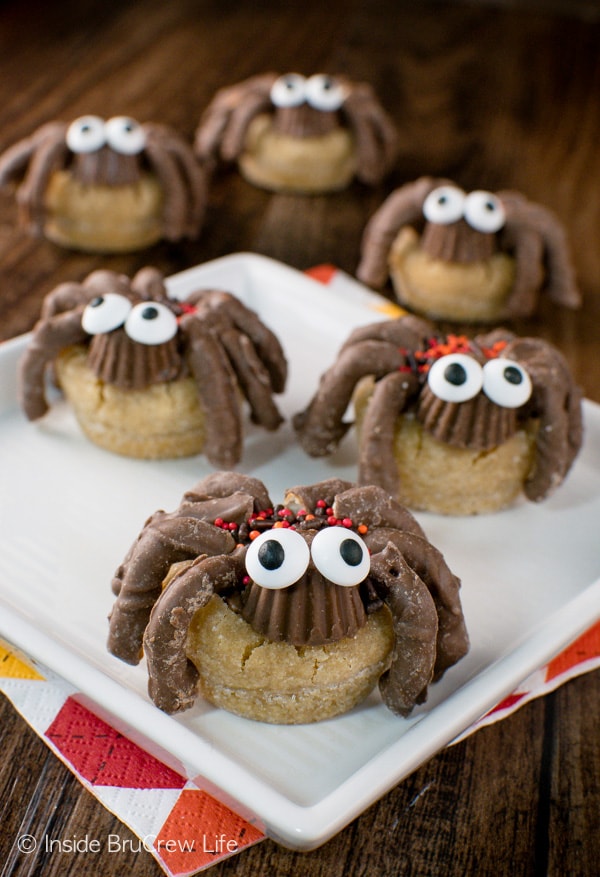 Peanut butter cup spider cookies with candy eyes on a white plate