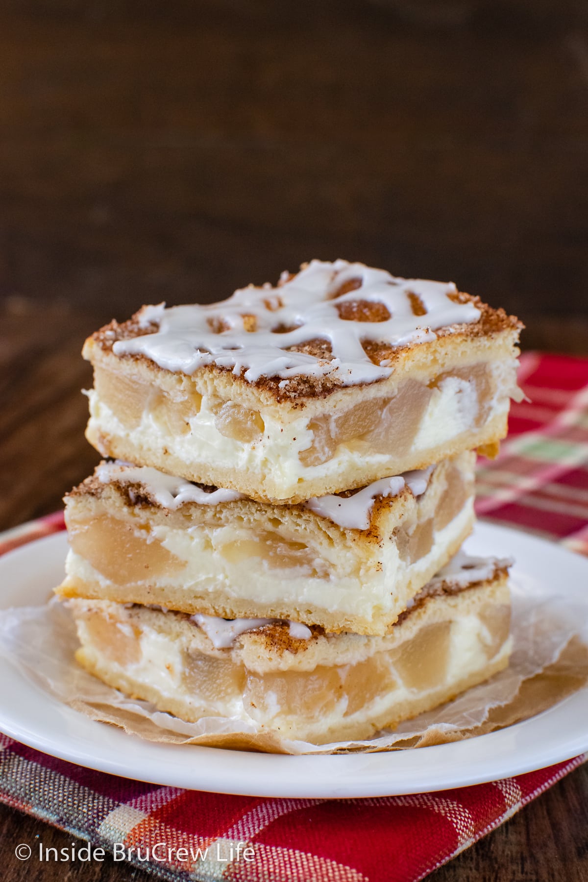 A stack of three apple crescent roll bars on a white plate.