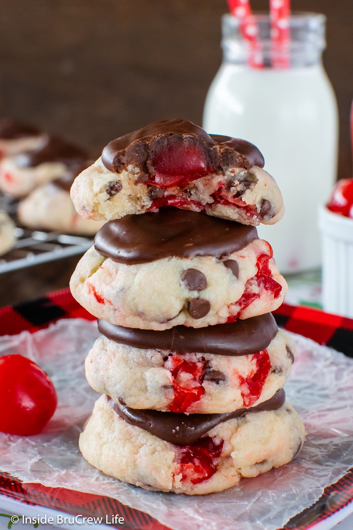 A stack of cake mix cookies topped with cherries and ganache.
