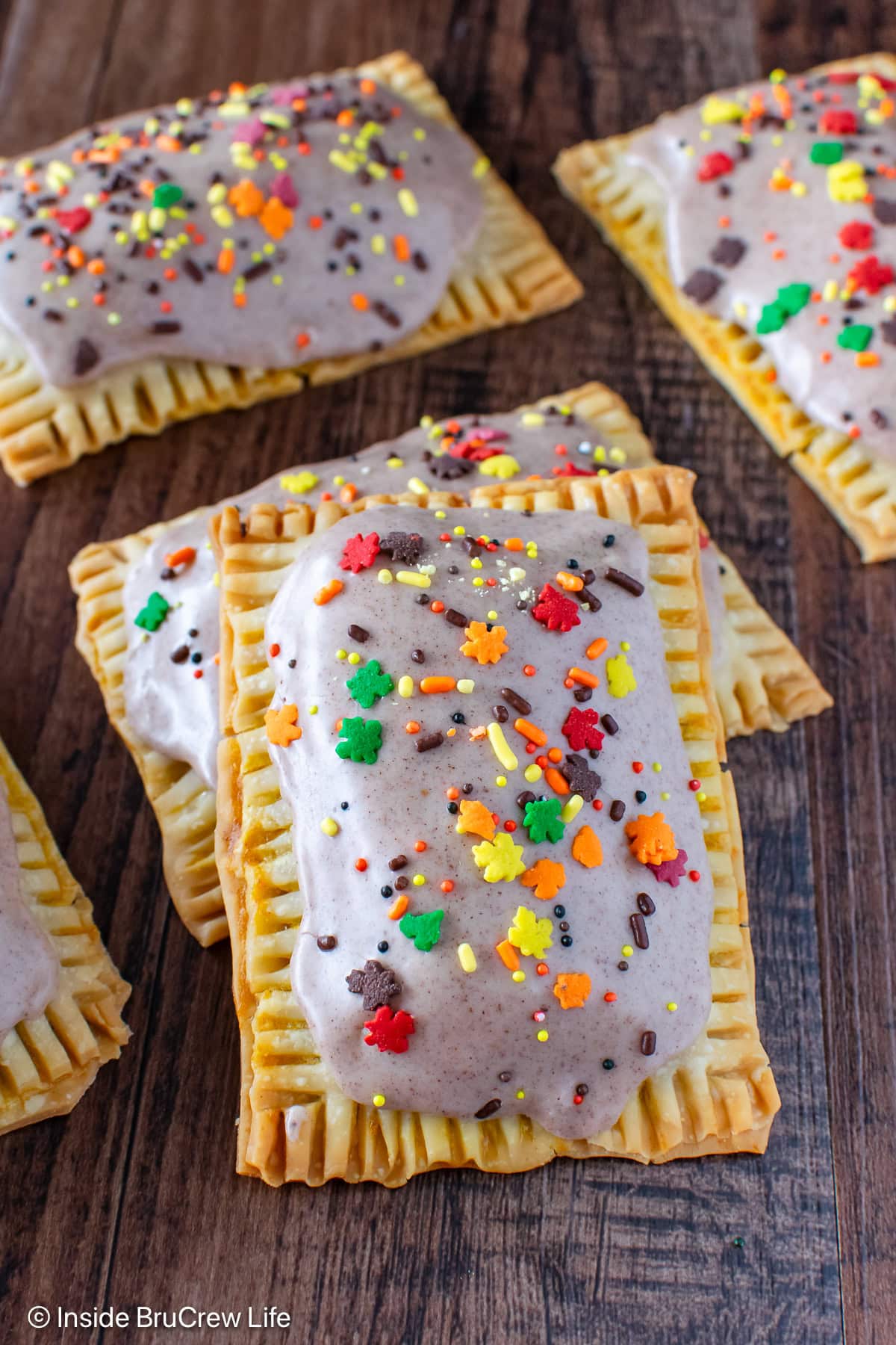 Frosted tarts on a wood board.