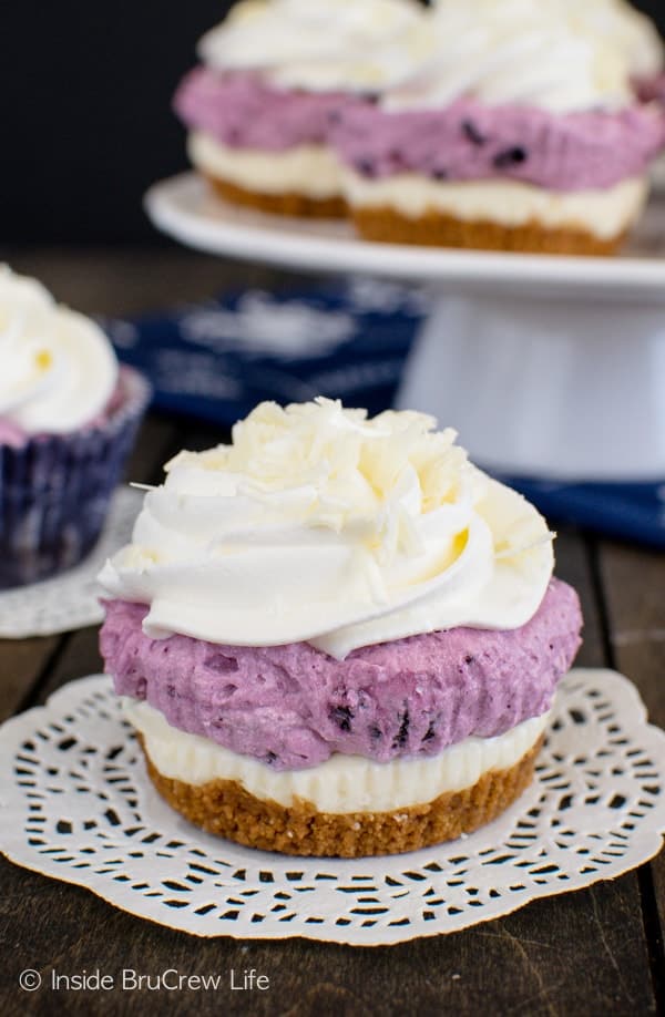 White Chocolate Blueberry Mousse Cheesecakes - layers of cookie, cheesecake, & a fluffy mousse makes this easy no bake dessert a hit with everyone. Great recipe for holiday parties!