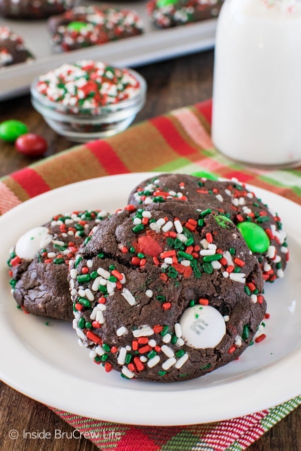 3 Chocolate Mint Pudding Cookies on a white plate covered in green, red, and white sprinkles.