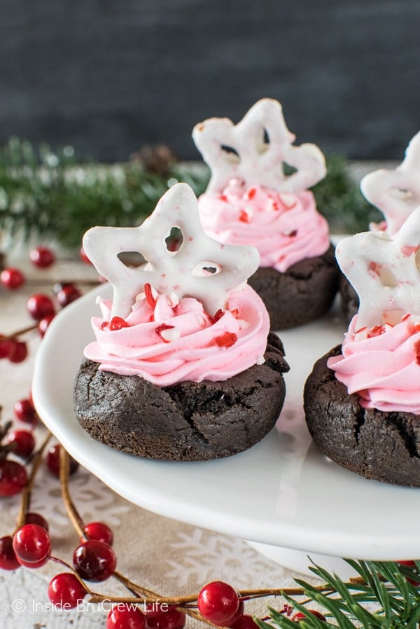 Swirls of creamy pink fluff and candy cane bits add a fun flair to these easy Chocolate Peppermint Fluff Cookie Cups. Great dessert recipe for holiday parties!