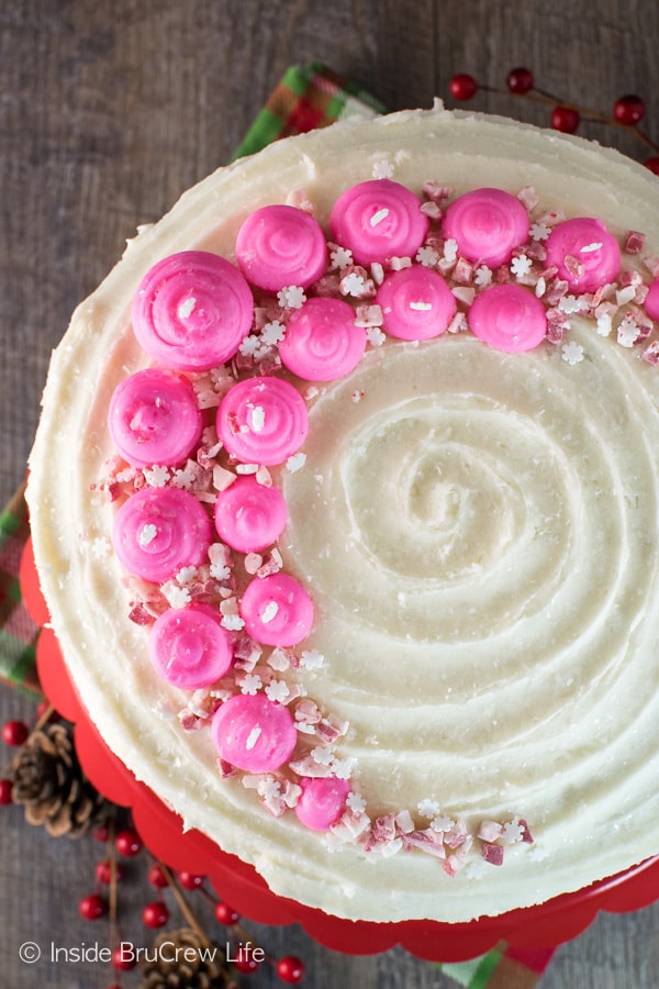 Pink frosting, candies, & sprinkles add a pretty and fun flair to this homemade Chocolate Peppermint Layer Cake. Great recipe for holiday parties!