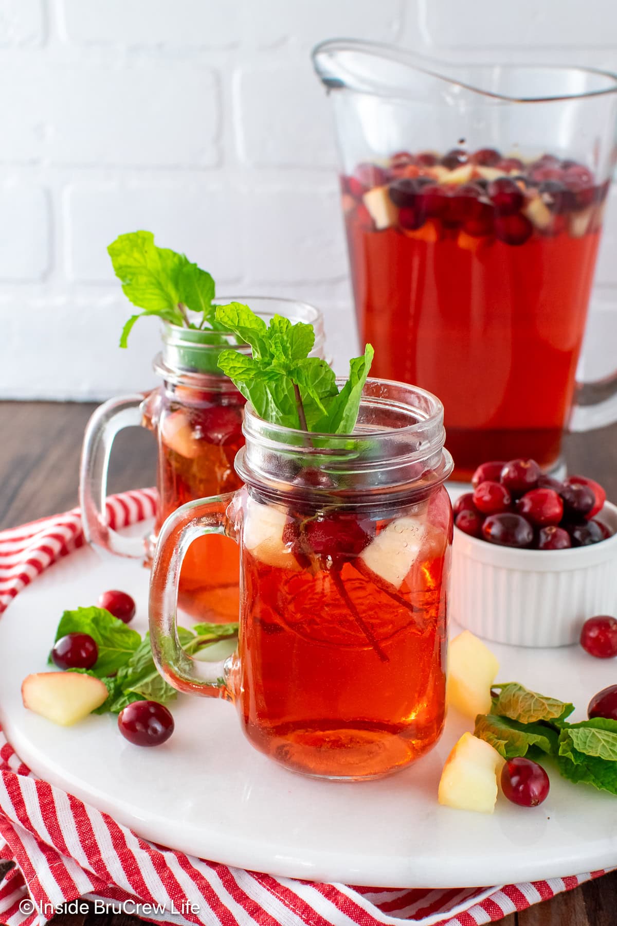 Two clear glasses filled with red holiday punch.