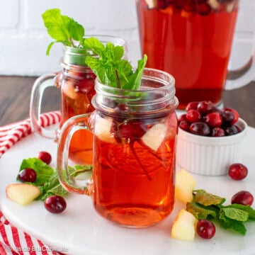 Two clear glasses filled with red holiday punch.