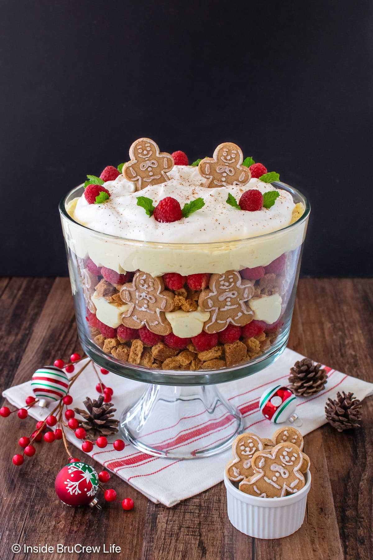 Layers of an eggnog trifle in a clear glass dish.