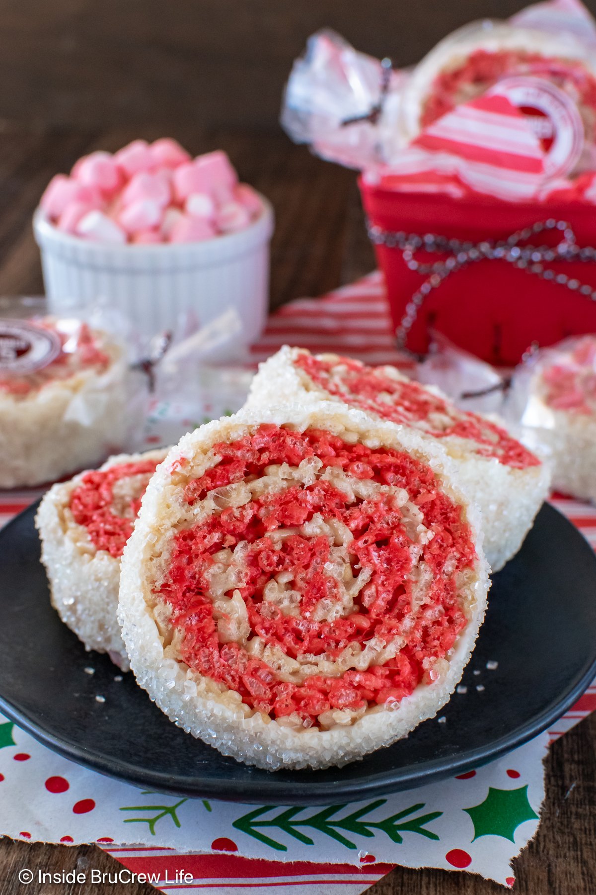 Peppermint rice krispie treat pinwheels on a black plate.