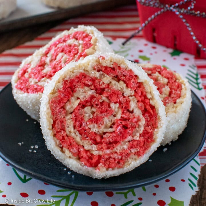 Peppermint rice krispie treat pinwheels on a black plate.