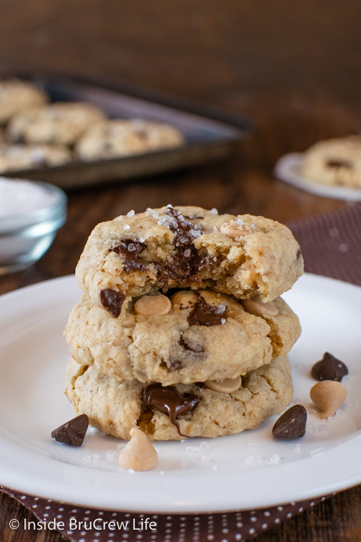 Gooey salted caramel chip cookies on a white plate.