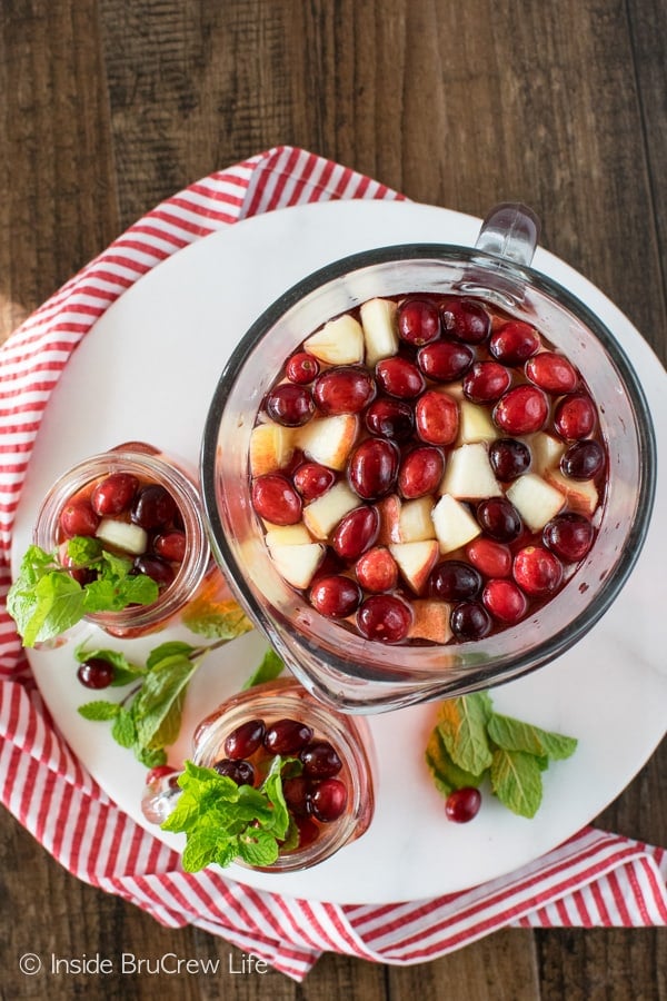 Overhead picture of a pitcher and two glasses filled with sparkling cranberry punch and fresh fruit