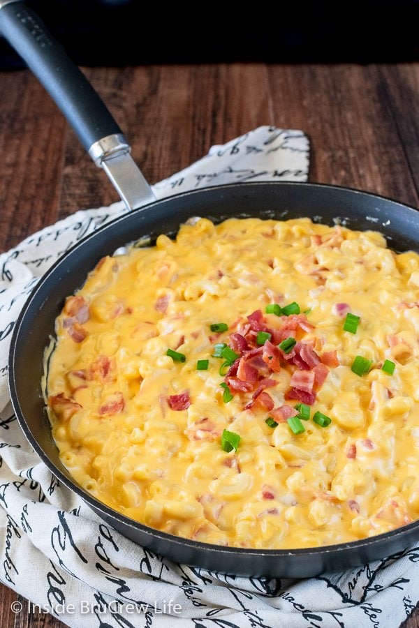 A black skillet filled with creamy mac and cheese with bacon.