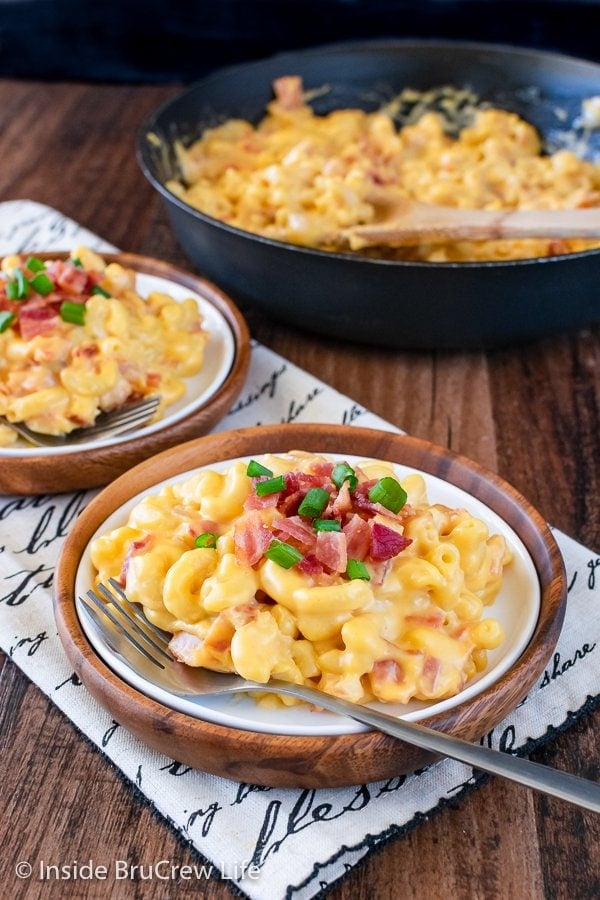 A white plate with a serving of cheesy bacon mac and cheese on it.