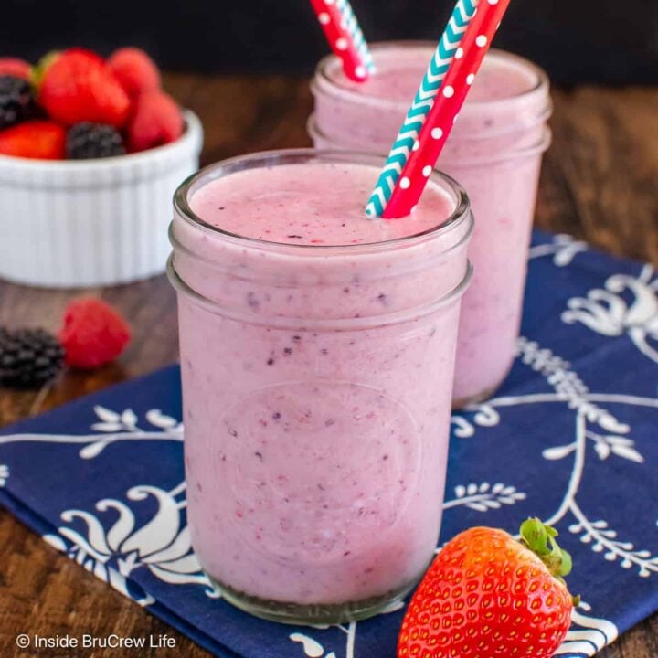 Two glasses filled with a pink berry orange smoothie.