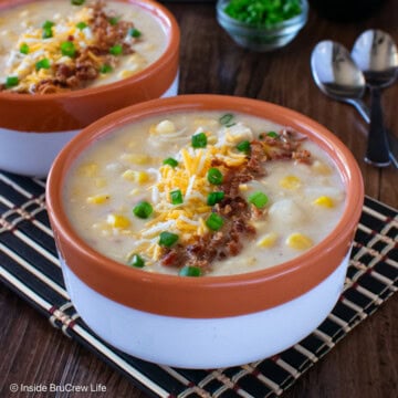 A bowl of chicken chowder topped with cheese and bacon.