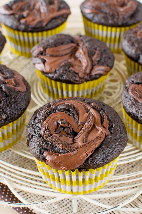 A close up picture of the top of a chocolate nutella banana muffin with more muffins behind it