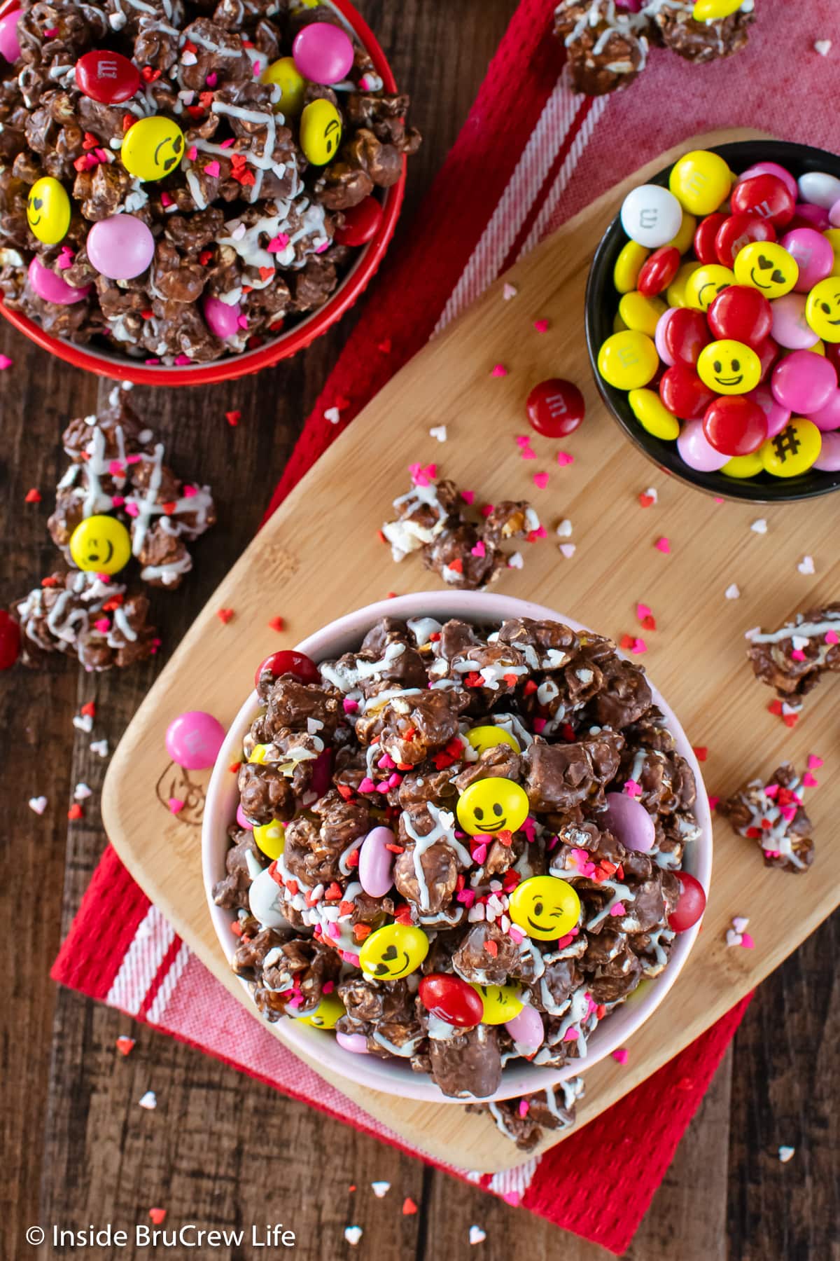 Bowls of popcorn with candies on a tray.