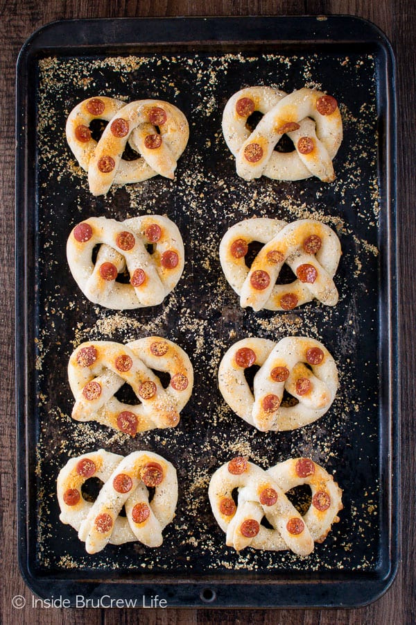 A pan with 8 pepperoni cheese pretzels on it.