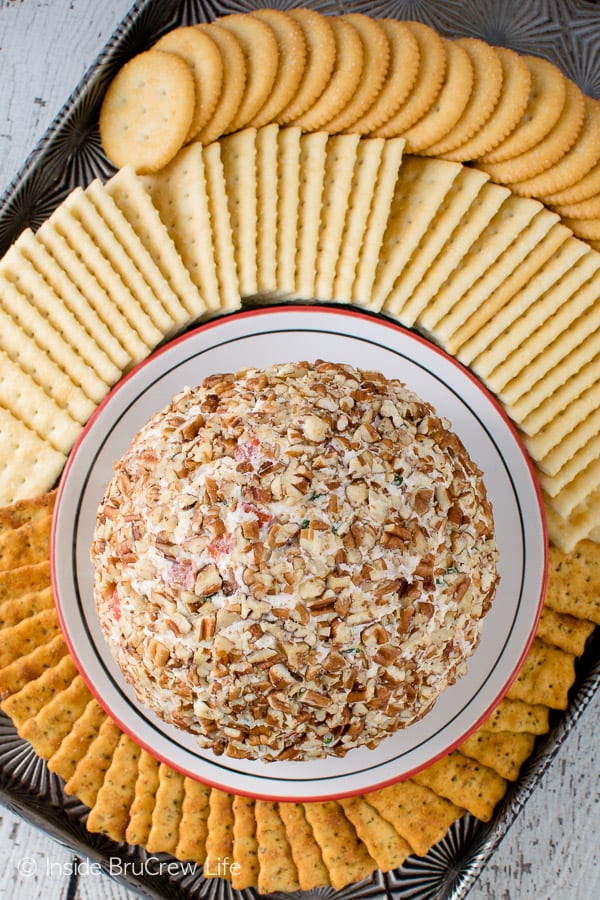 An overhead picture of a cheeseball surrounded by an assortment of crackers.