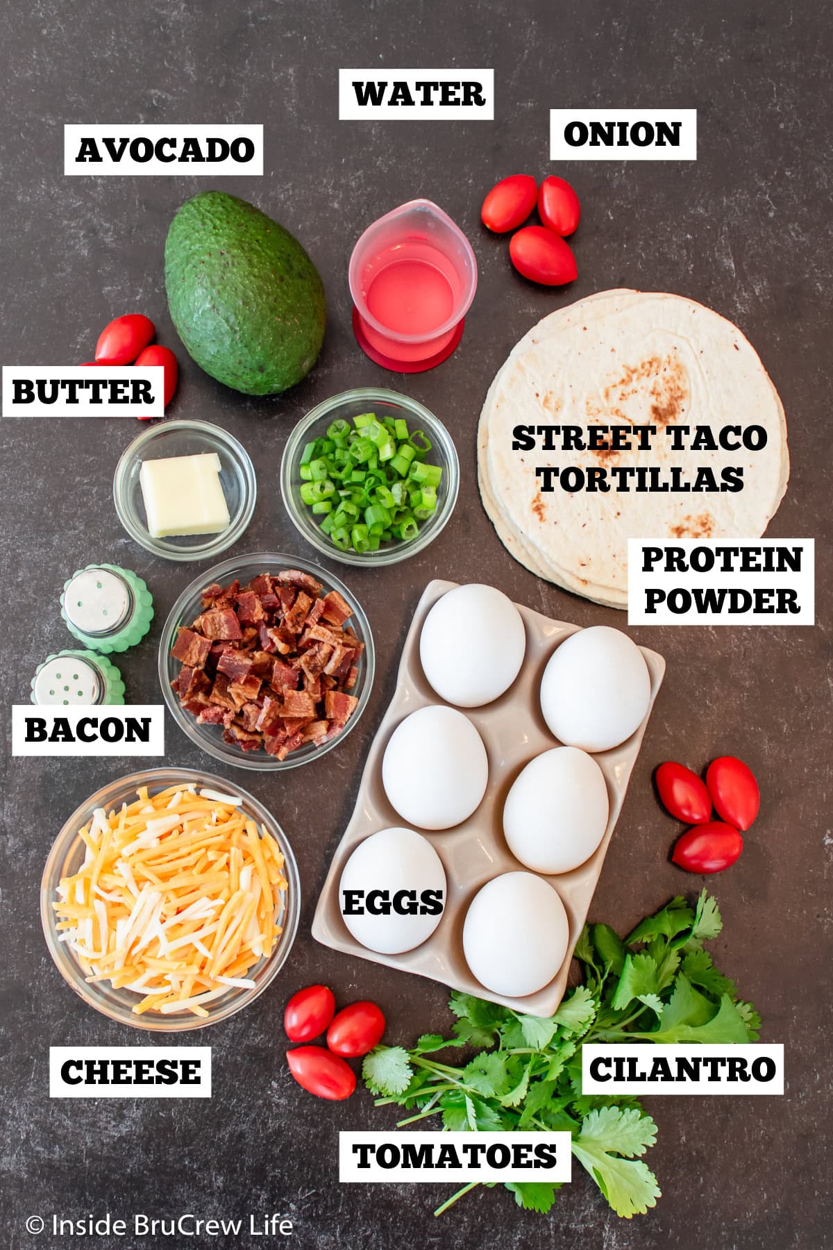 A black board with ingredients needed to make breakfast tacos.