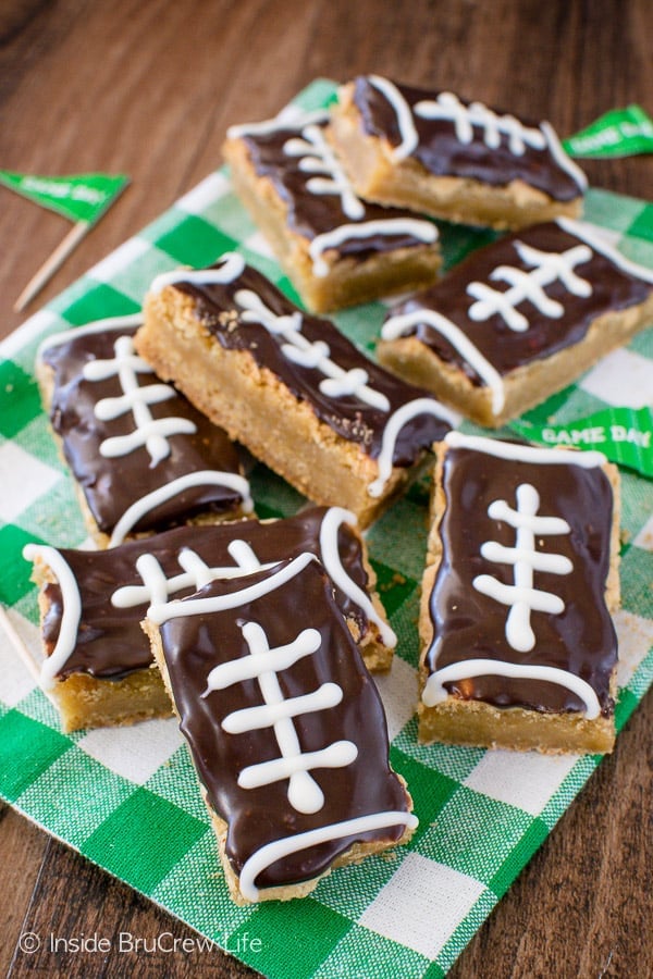 A white and green towel with football cookie bars piled on it