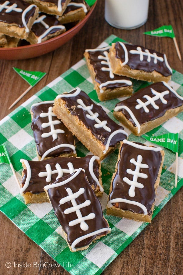 Football cookie bars piled and stacked on a white and green towel