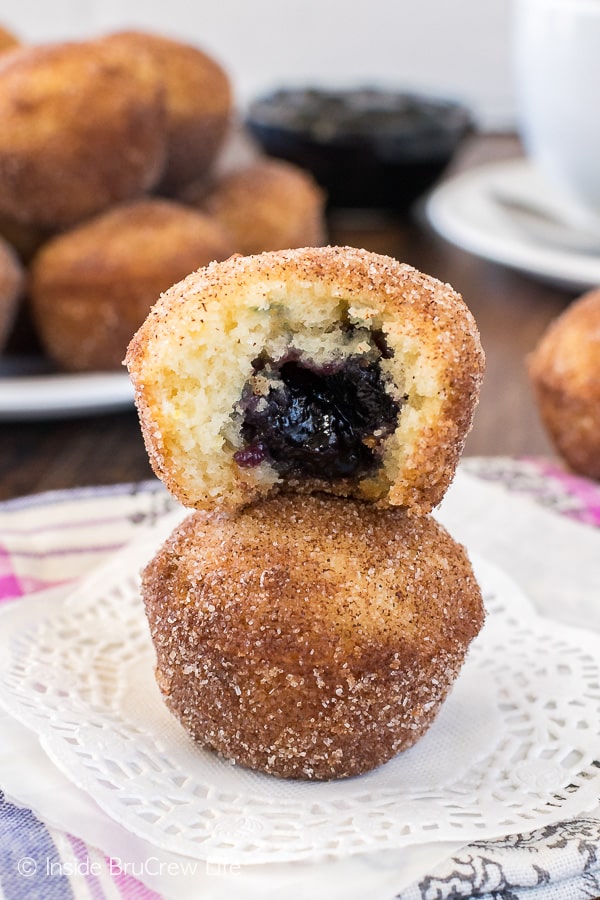 Two Blueberry Jelly Donut Holes stacked on top of each other with a bite out of the top donut