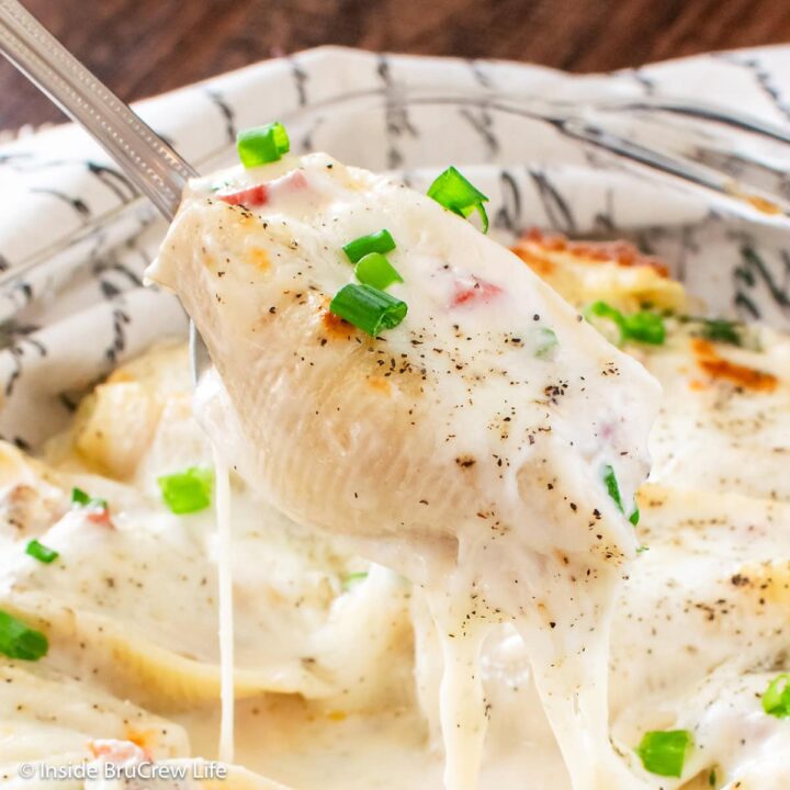 A cheesy pasta shell on a spoon.