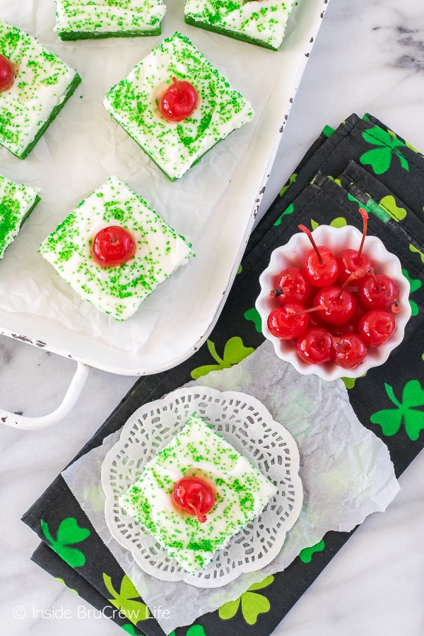 Overhead picture of shamrock shake sugar cookie bars on a white tray and on a black towel