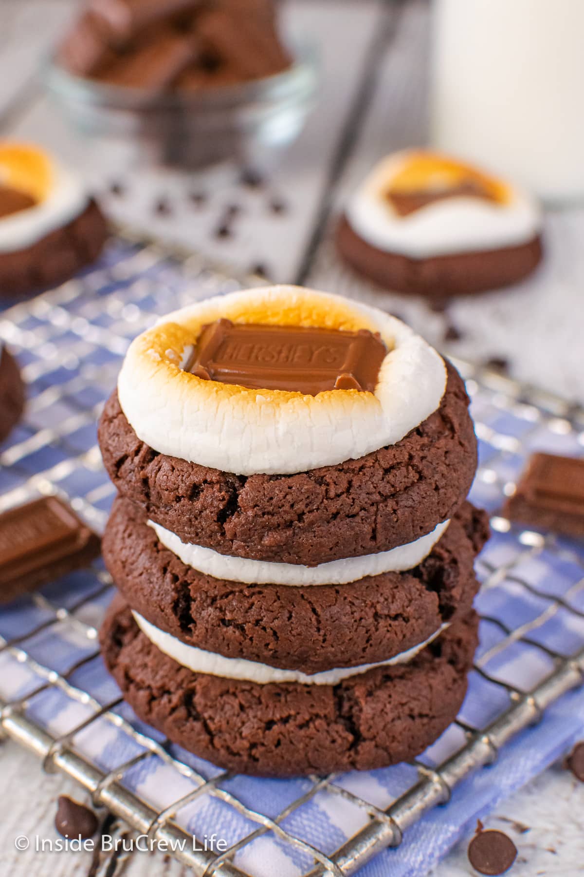 A close up of a stack of chocolate cookies with marshmallows.