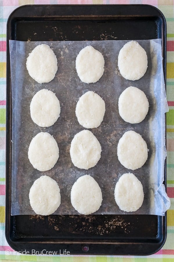 12 coconut cream eggs on a cookie sheet.