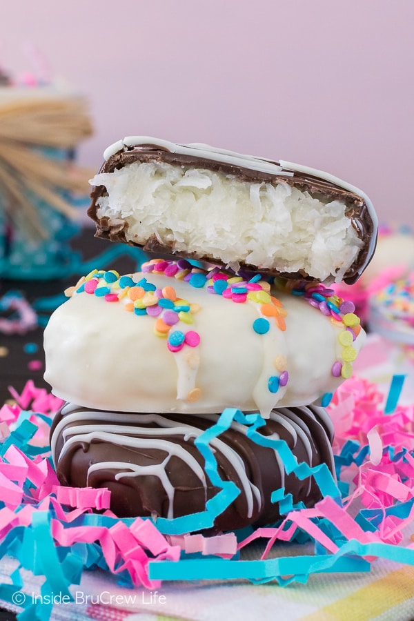 Decorated chocolate covered cream eggs filled with coconut stacked on top of each other.