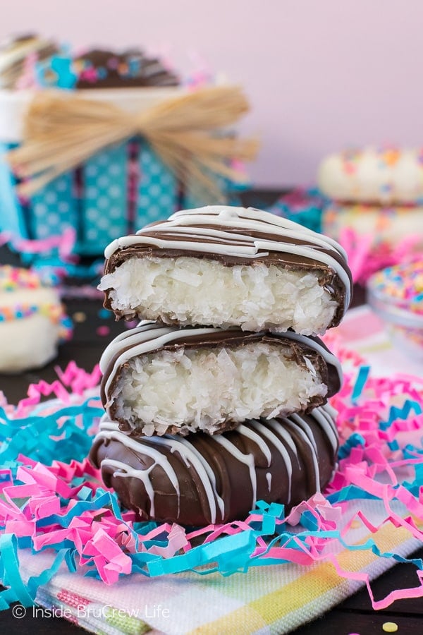 Chocolate covered cream eggs filled with coconut surrounded by blue and pink decorative paper strips.