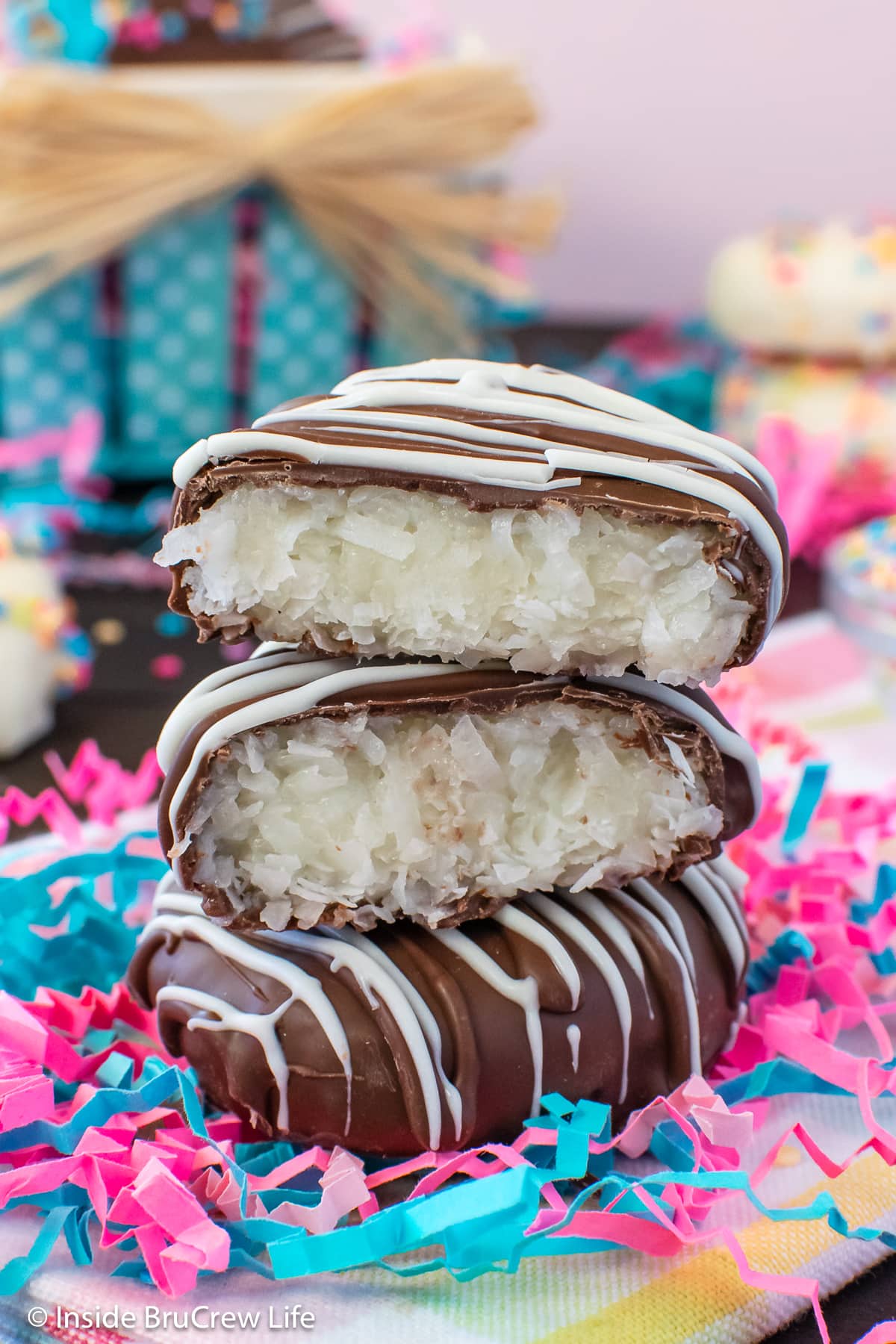 A stack of chocolate covered coconut eggs on a towel.