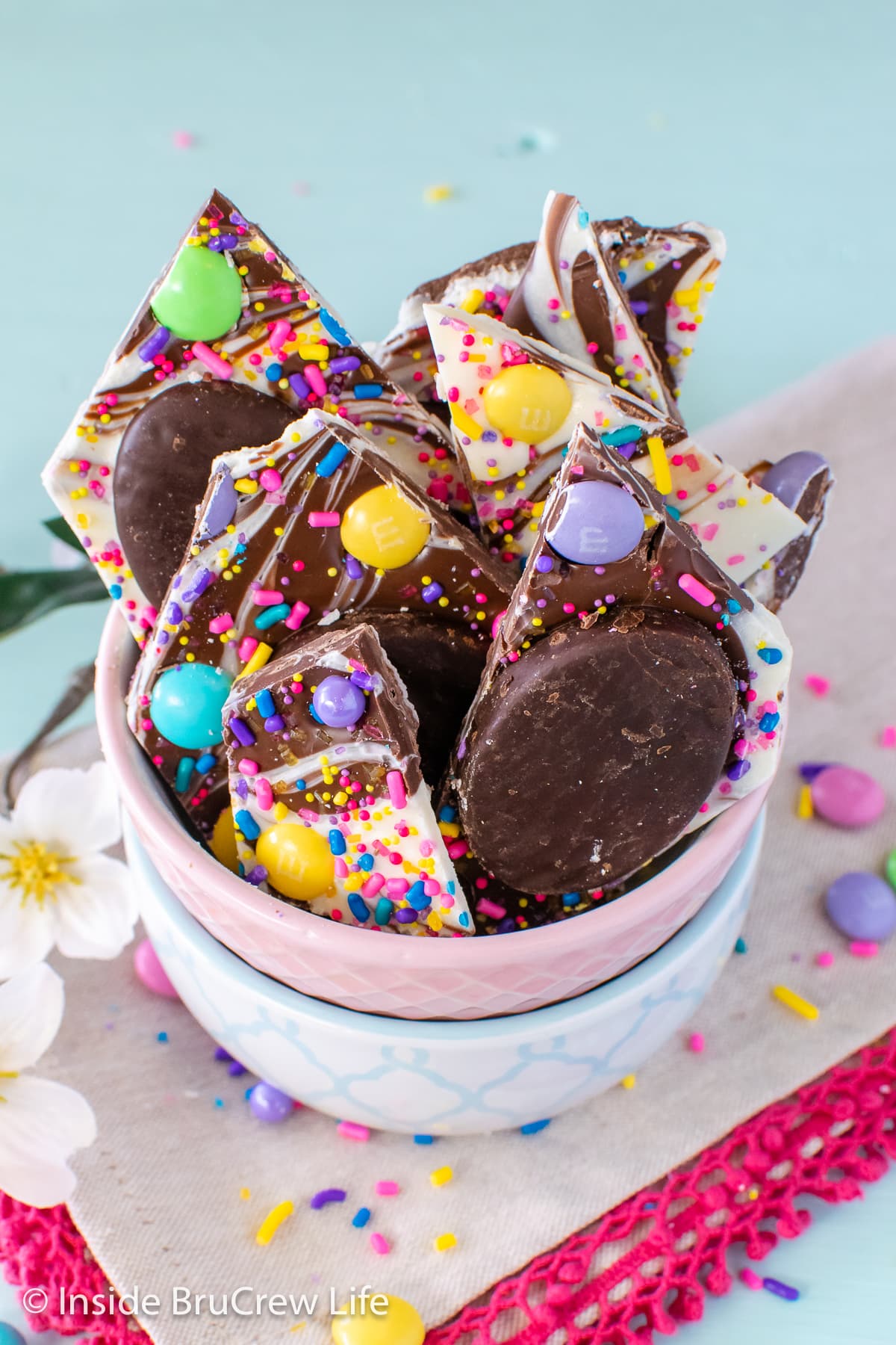 Chunks of swirled chocolate bark with candies in a bowl.