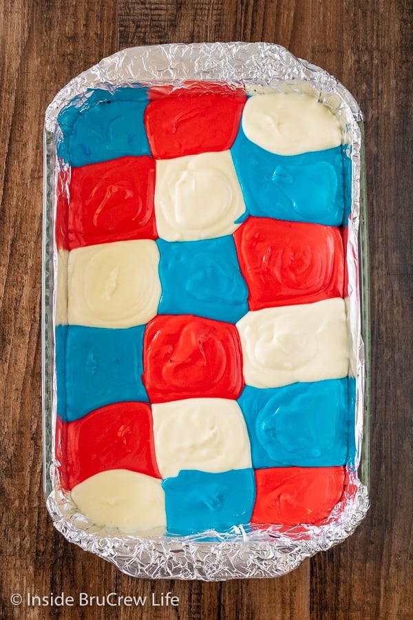 A pan of cheesecake bars with a grid of red white and blue colors