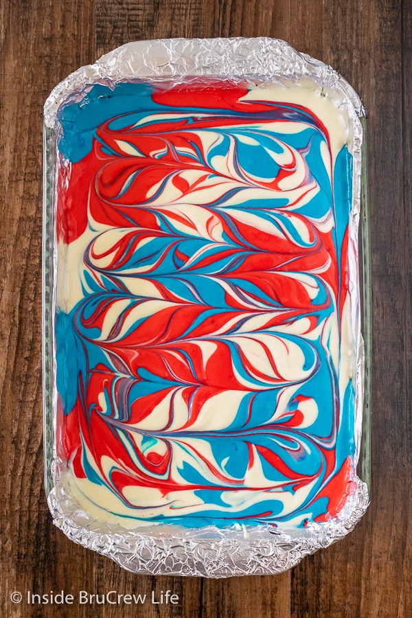 A pan of cheesecake bars with swirls of red white and blue colors