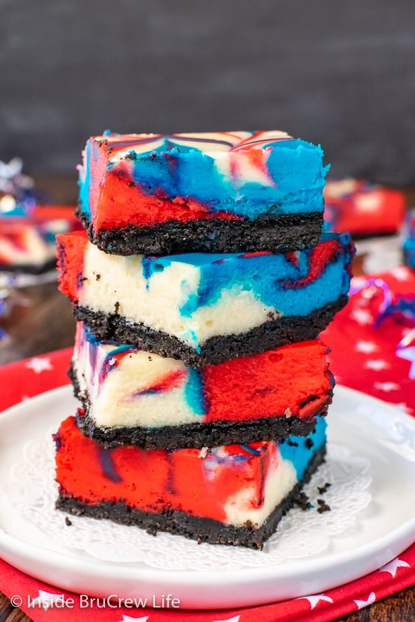 A stack of four red white and blue cheesecake bars on a white plate