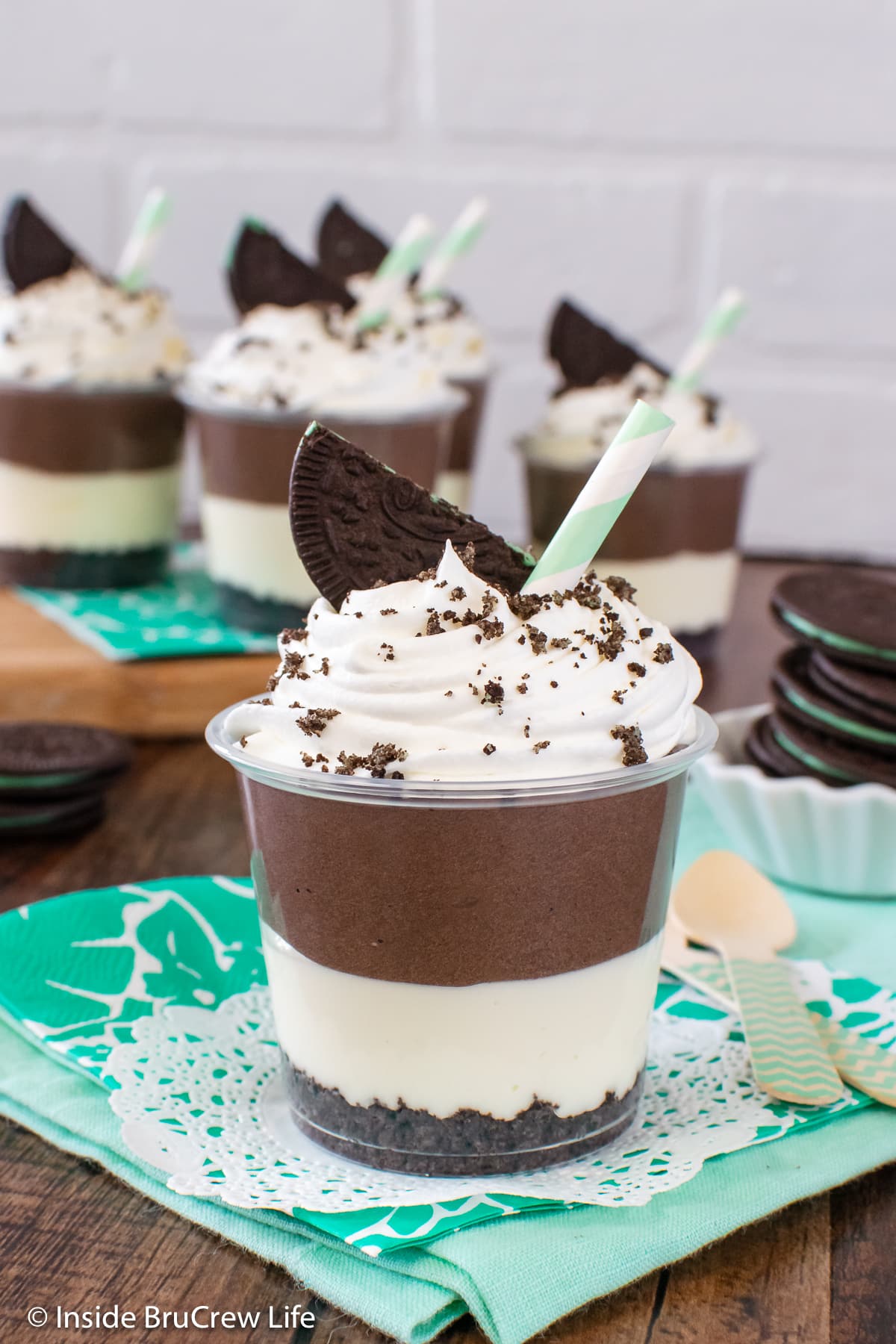 A clear cup filled with a mint and chocolate cheesecake filling.